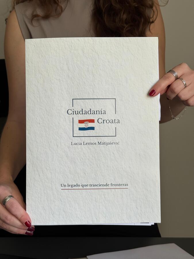 Persona sosteniendo la carpeta oficial de Ciudadanía Croata durante una presentación del servicio